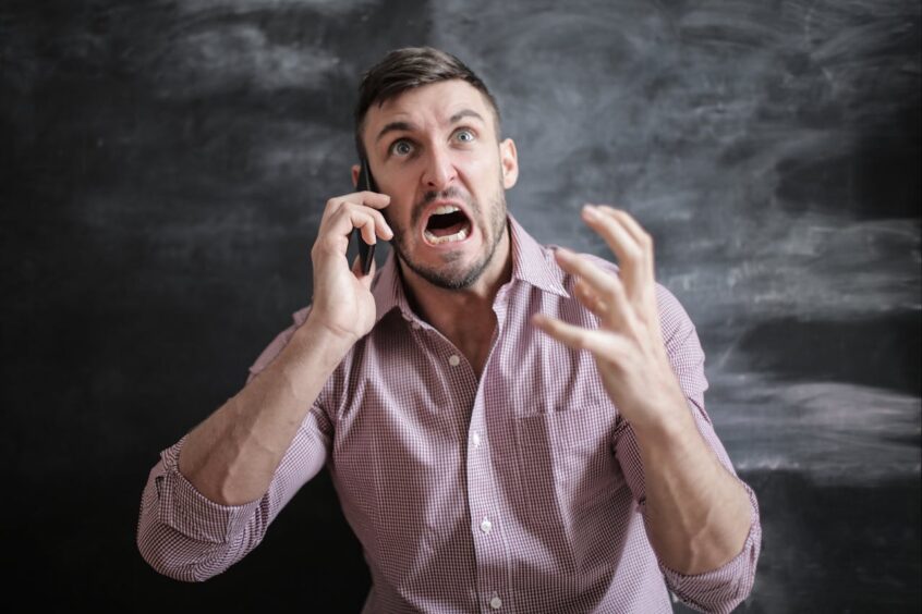 Stressed Man in Pink Dress Shirt on Phone