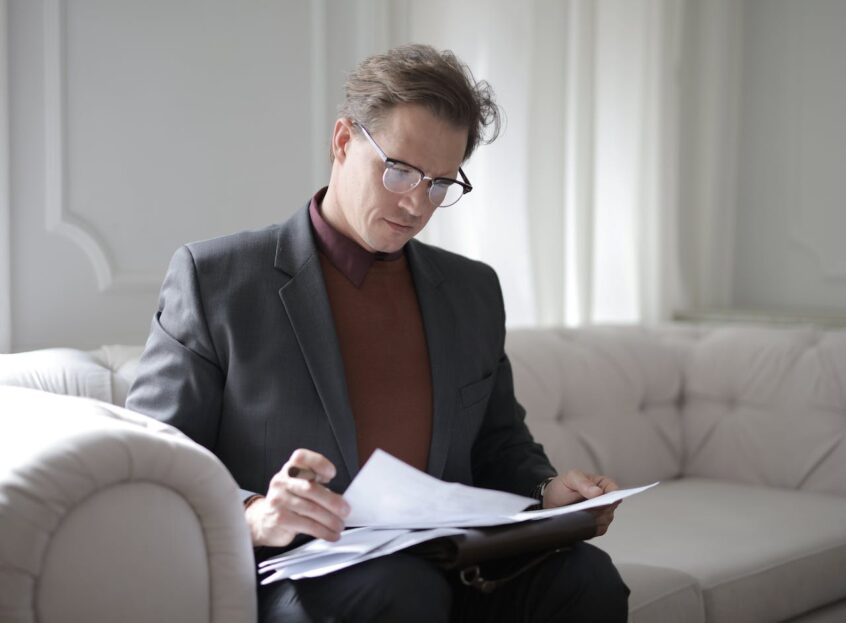 Executive male reading papers on couch