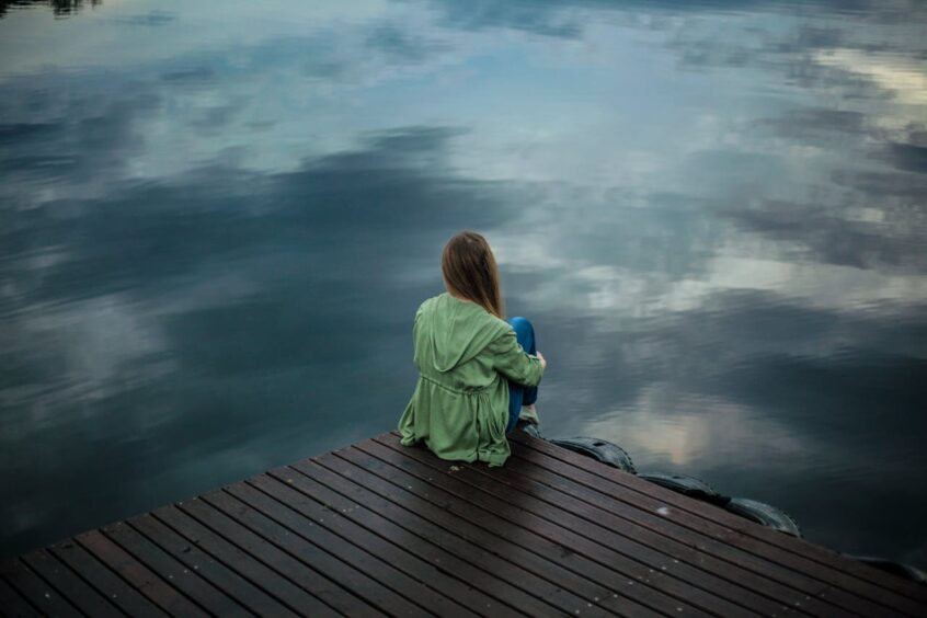 Woman sitting at the end of a dock